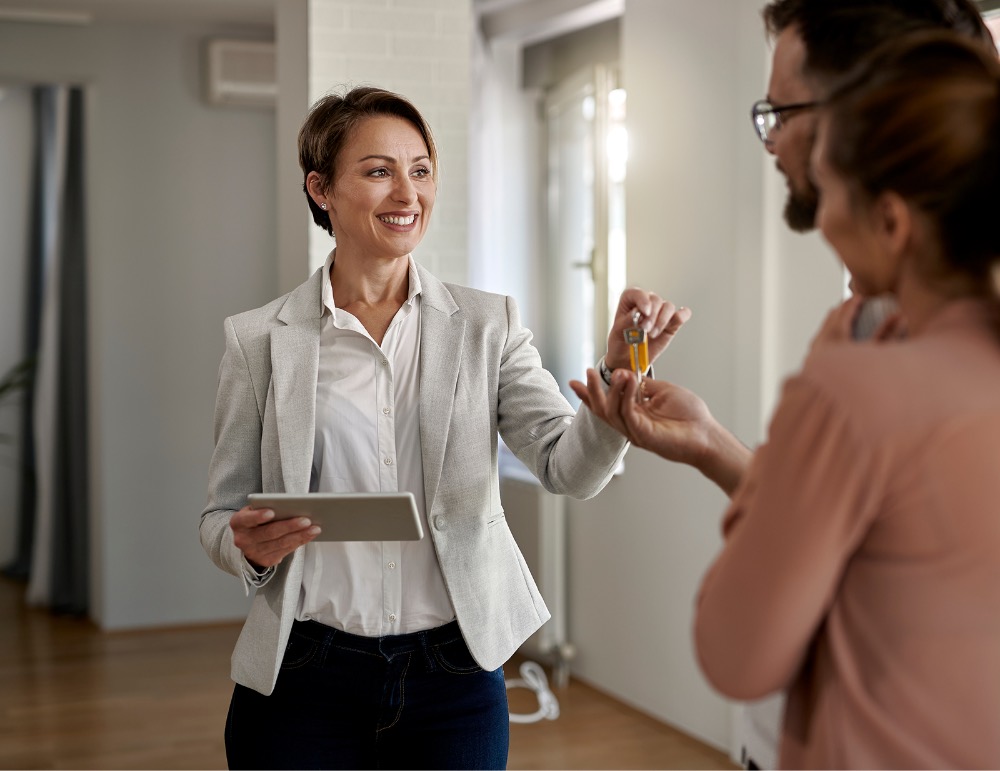 A Foundation Home Loans advisor handing house keys to a couple in their new home.